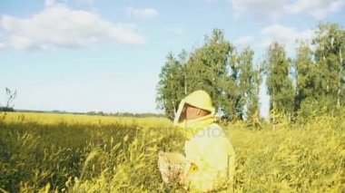 Ahşap çerçeve içinde arı kovanı çalışırken çiçeği alanına yürüme ile atış arıcı adamın pan