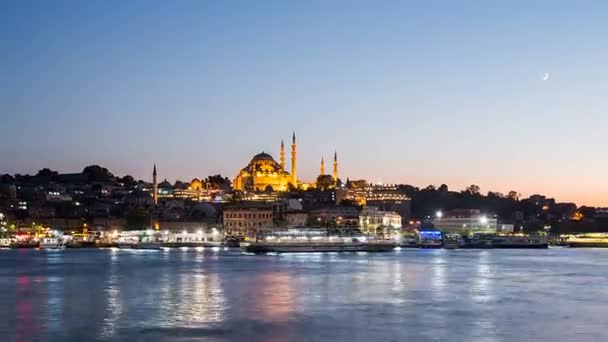 Timelapse uitzicht op Istanbul stadsgezicht met Suleymaniye moskee uitzoomen met toeristische schepen, drijvende op Bosporus 's nachts — Stockvideo