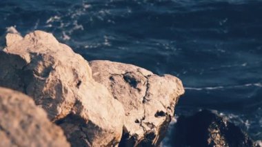 Okyanus dalgaları karşı taş plaj yenerek Slowmotion