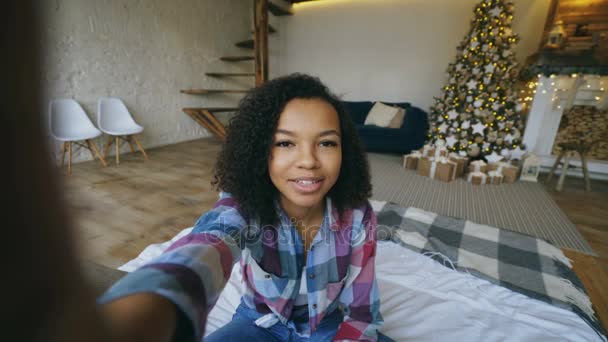 Giovane ragazza afroamericana chatta conversazione online utilizzando la fotocamera dello smartphone a casa a Natale — Video Stock