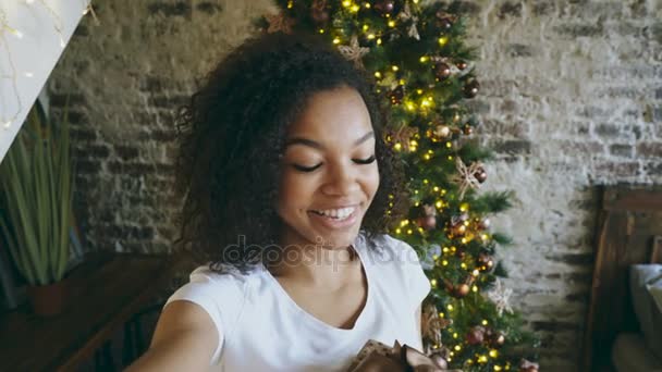 Fotoğraf makinesinde smartphone evde Noel ağacı yakınındaki selfie resimleri alarak komik karışık yarış kız — Stok video