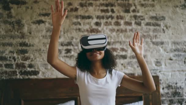 Кудрявая африканская американка получает опыт использования VR 360 гарнитуры очки виртуальной реальности дома — стоковое видео