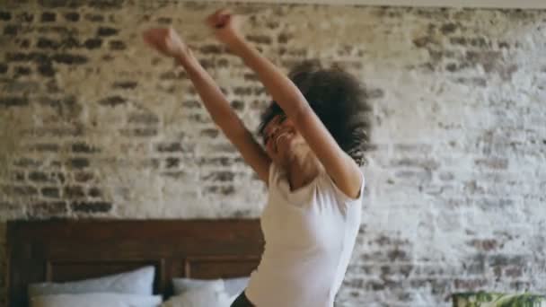 Attraente razza mista giovane donna gioiosa divertirsi ballando vicino al letto a casa — Video Stock