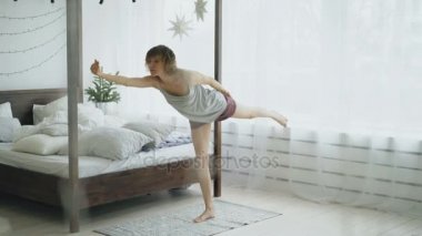 Yatak odası evde yatakta yakınındaki Yoga egzersiz yaparak mutlu çekici kadın