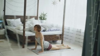 Yatak odası evde yatakta yakınındaki Yoga egzersiz yaparak mutlu çekici kadın