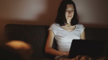 Gece zamanında evde dizüstü bilgisayar üzerinde çalışan kadın