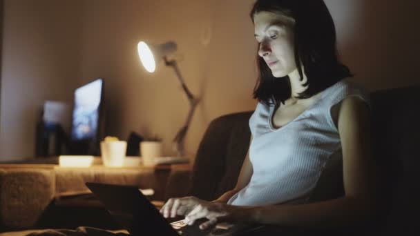 Junge attraktive Frau teilt soziale Medien mit dem Laptop zu Hause in der Nacht — Stockvideo