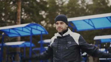 Genç çekici açık havada kış parkta çalıştırmadan önce ısınma jogging yapan adam