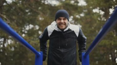 Kış park açık havada barlarda şınav egzersiz yapan genç atlet erkek