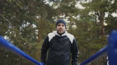 Kış park açık havada barlarda şınav egzersiz yapan genç atlet erkek