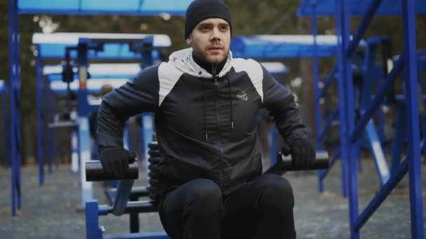 Hombre atleta guapo haciendo ejercicio en el gimnasio al aire libre en el parque de invierno — Vídeos de Stock