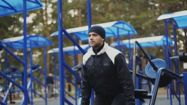 Homme athlète attrayant faisant de l'exercice à la salle de gym extérieure dans le parc d'hiver — Video