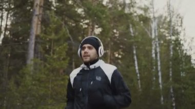 Yakışıklı runner adam kış Park müzik dinleme sırasında sabah koşu kulaklık