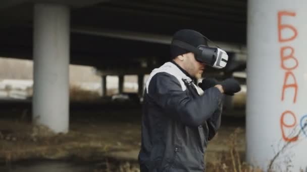 Nyomon követése, ezen a környéken: shot box ember Vr-360 headset képzés ütéseket, virtuális valóság harcban városi helyen szabadban télen — Stock videók