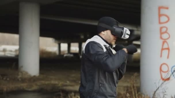 Monitoraggio dello scatto dell'uomo della boxe in VR 360 colpi di allenamento cuffie in realtà virtuale lotta in posizione urbana all'aperto in inverno — Video Stock