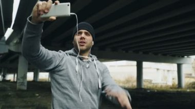 Görüntülü sohbet smartphone cep telefonu ile arkadaş grubu egzersiz yaptıktan sonra kentsel konumda açık havada kışın sahip Boxer erkek