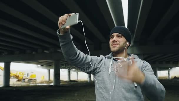 Sportler plaudert nach dem Training im Winter im Freien mit seinem Trainer per Smartphone — Stockvideo