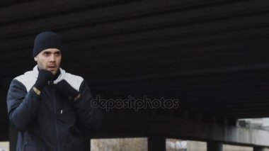 Sportif adam boksör boks egzersiz kentsel konumda açık havada kışın yaparak Slowmotion