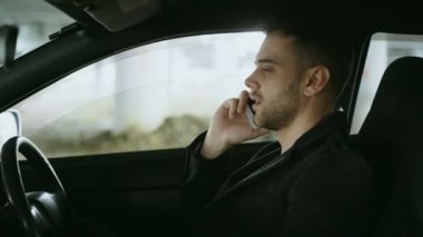 Küfür ve açık havada araba içinde otururken telefonu konuşurken adam vurguladı