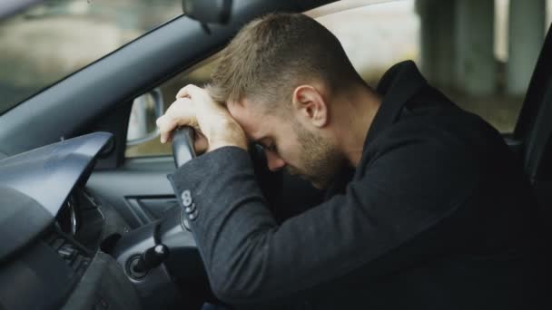 Jovem sentado dentro do carro é muito chateado e estressado — Vídeo de Stock