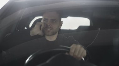 Üzgün ve kızgın adam araç açık havada içinde otururken telefonu konuşurken