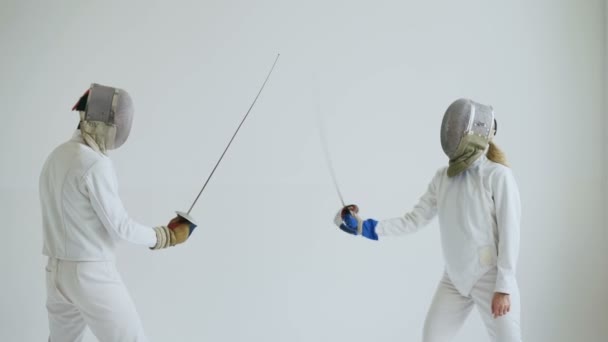 Два фехтовальщика проходят обучение фехтованию на белом фоне — стоковое видео