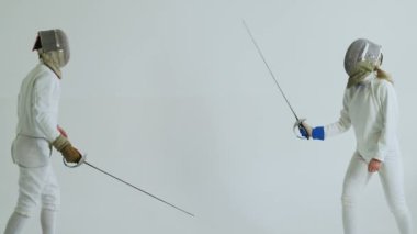 Beyaz arka planda kapalı eğitim eskrim iki eskrimcilerin var