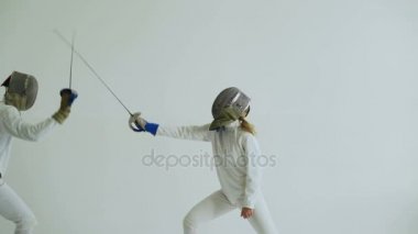 İki eskrimcilerin eskrim beyaz arka plan üzerinde kapalı maç var