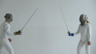 İki eskrimcilerin eskrim beyaz arka plan üzerinde kapalı maç var