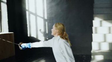 Genç eskrimci kadın eğitim eskrim konsantre saldırı egzersiz Studio kapalı