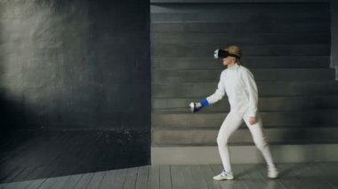 Sanal gerçeklik kulaklık Eğitim Simülatörü oyunu kapalı eskrim oynamak için kullanan konsantre fencer kadın