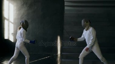 Eskrim kapalı eğitim Slowmotion iki eskrimcilerin erkek ve kadın var