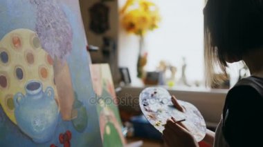 Genç sanatçı kadın Close-Up paleti ve boyama natürmort resim tuval sanat Studio üzerine fırça ile boya karışımı