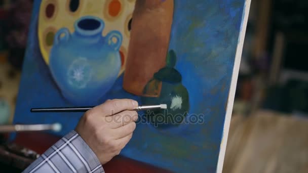 Close-up van kunstenaars hand schilderij op doek in kunst workshop — Stockvideo