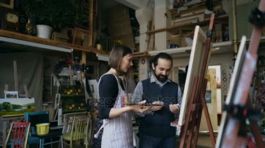 Sanatçı resim çizmek için öğretim genç kız erkek gülümseyen ve temel sanat atölyesi olarak açıklayan