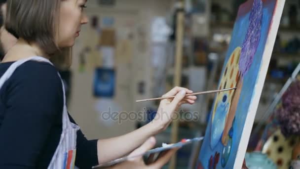 Professor de artista especializado mostrando e discutindo conceitos básicos de pintura para o estudante na aula de arte — Vídeo de Stock