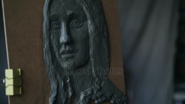 Close-up of Sculptor creating sculpture of womans face on canvas in art studio — Stock Video