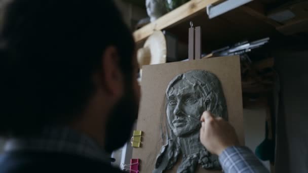 Close-up van beeldhouwer maken beeldhouwkunst van dames gezicht op canvas in art studio — Stockvideo