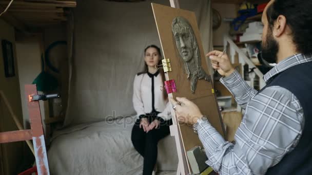 Sculpteur qualifié travaille avec de la plasticine sur toile pour créer des femmes visage de pose modèle en atelier d'art — Video