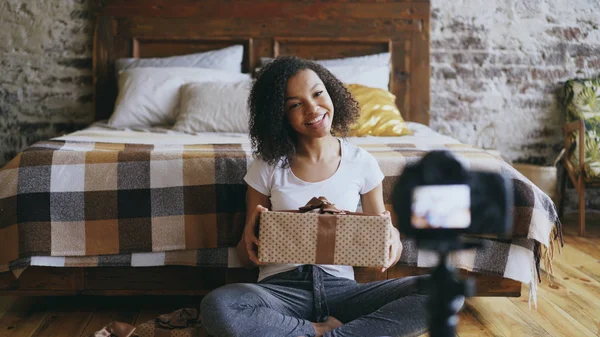 Νέος, χαμογελαστός Αφρικής κορίτσι καταγραφή βίντεο blog για συσκευασίας πλαίσιο δώρο Χριστουγέννων στο σπίτι — Φωτογραφία Αρχείου