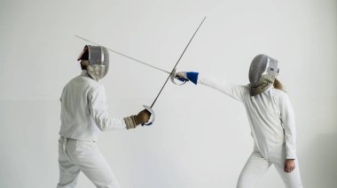 Eğitim eğitmen beyaz Studio kapalı ile eskrim sahip genç kadın fencer