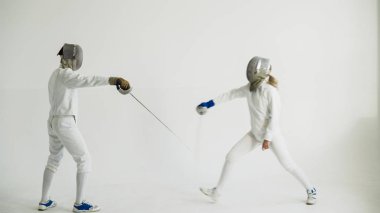 Eğitim eğitmen beyaz Studio kapalı ile eskrim sahip genç kadın fencer