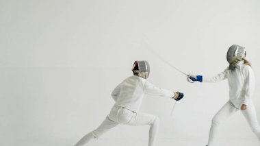 Eğitim eğitmen beyaz Studio kapalı ile eskrim sahip genç kadın fencer