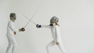 Eğitim eğitmen beyaz Studio kapalı ile eskrim sahip genç kadın fencer