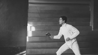 Genç egzersizleri eskrim ve rekabete kapalı Studio eğitim fencer adam uygulama konsantre