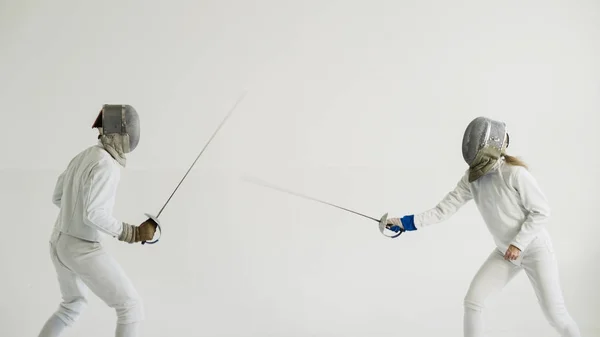 Dos esgrimistas tienen entrenamiento de esgrima sobre fondo blanco — Foto de Stock