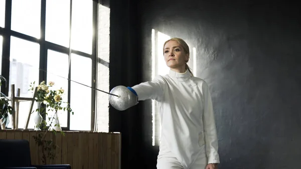 Jóvenes esgrimistas concentrados practican ejercicios de esgrima y entrenamiento para la competencia en estudio en interiores —  Fotos de Stock