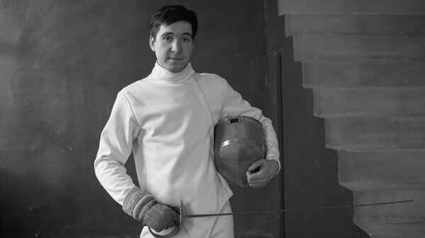 Portrait of young fencer man smiling and looking into camera indoors