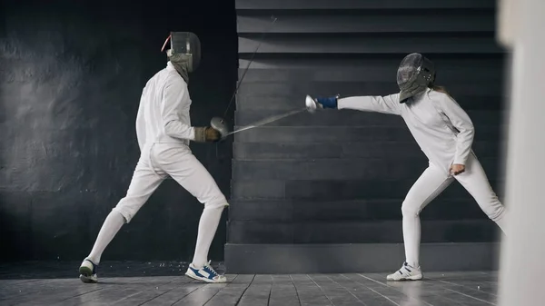 Two fencers man and woman have fencing match indoors — Stock Photo, Image