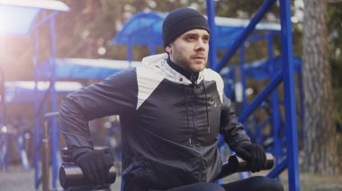 Kış Park açık spor salonunda egzersiz yaparak kas genç adam